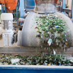 Glass particles for recycling in a machine in a recycling facility. Different glass packaging bottle waste. Glass waste management. Glass recycling is the process of waste glass into usable products.